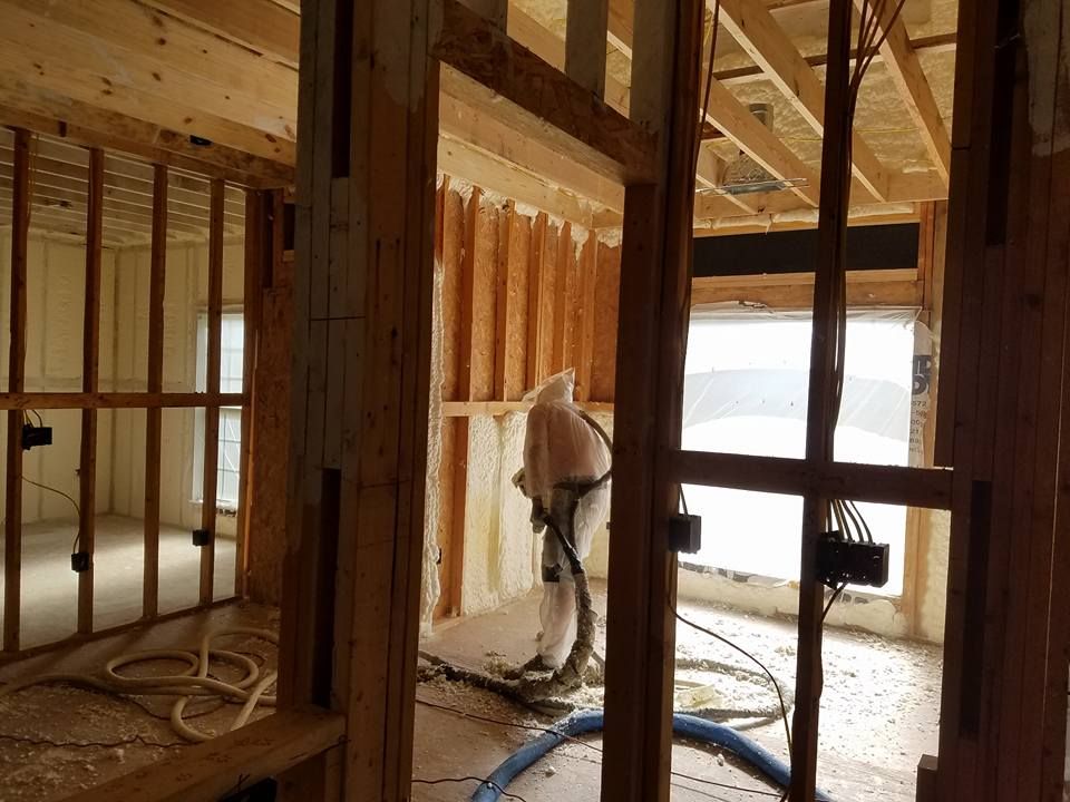 Modern Foam & Insulation installer spraying foam into wall cavities